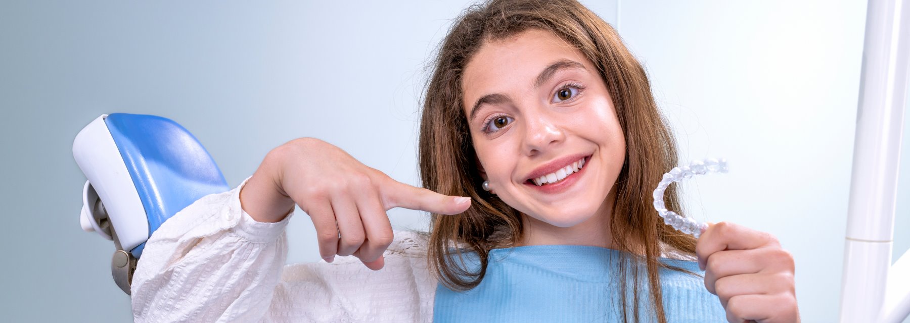 Girl Smiles Brightly While Holding A Aligner at Meadville Pennsylvania