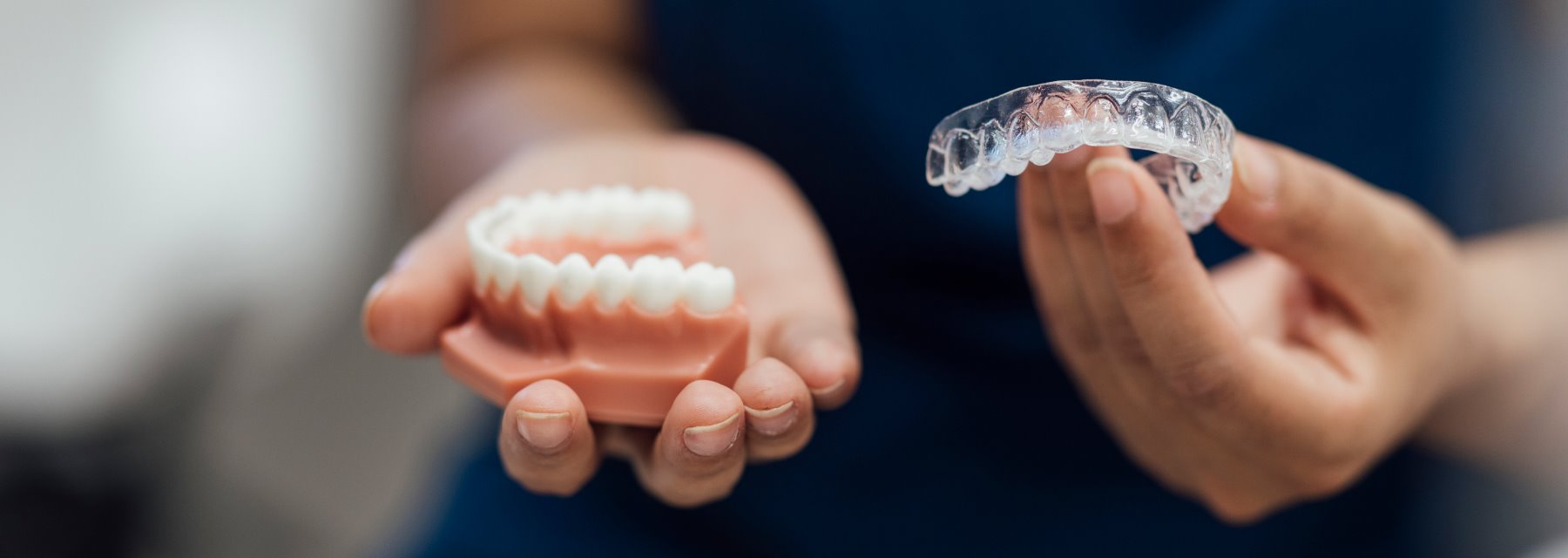 Person Displaying a Tooth With a Dental Implant at Meadville Pennsylvania