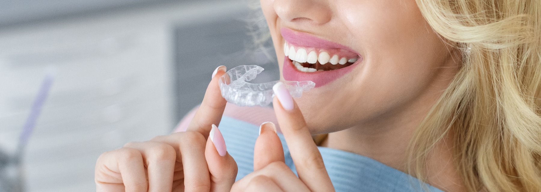 Woman Smiling While Holding a Clear Orthodontic Aligner at Meadville Pennsylvania