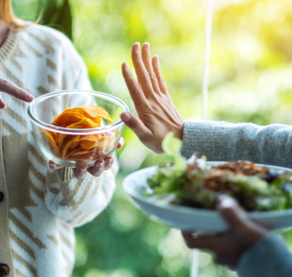 Two Women Holding Hands While Sharing A Bowl Of Salad at Meadville Pennsylvania