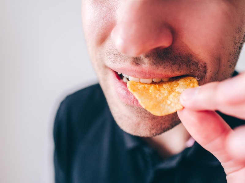 Man Takes a Bite Of a Potato Chip at Meadville Pennsylvania